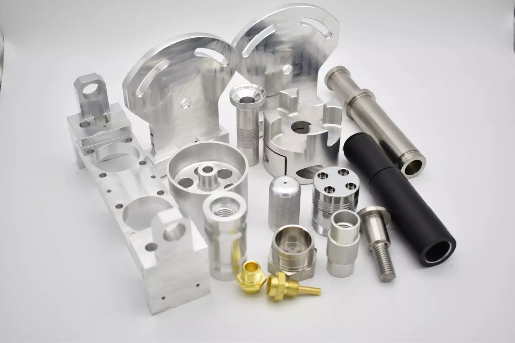 How to Design Parts for CNC Machining: Complete DFM Guidelines for Engineers 2 Different CNC machined metal parts made from aluminum, stainless steel, titanium, and other materials used for precision manufacturing applications.